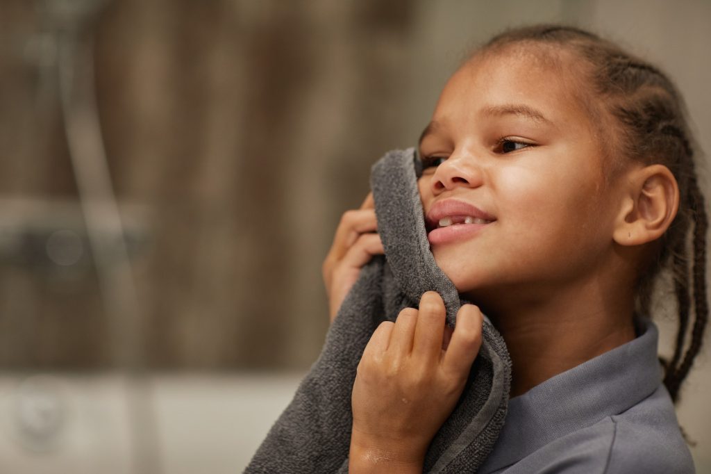 Little Girl Washing Face in Bathroom